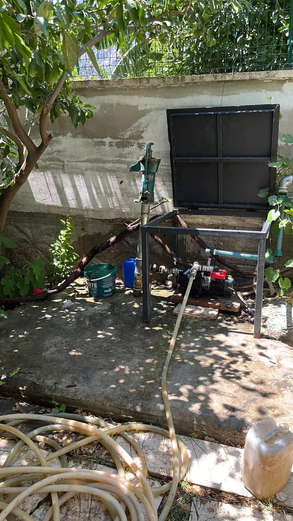 Bahçedeki kuyu başı, borular ve pompa tesisatı